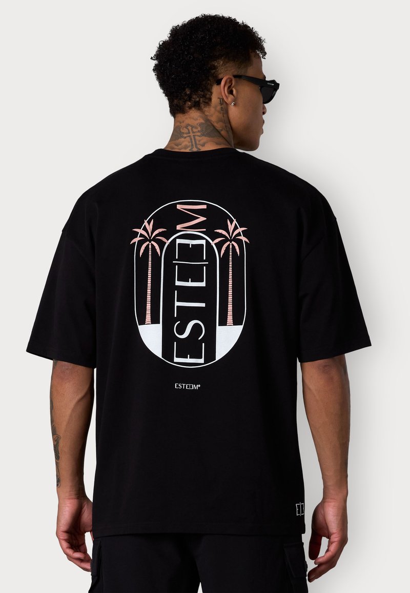 T-shirt en coton noir avec un design graphique comprenant des palmiers roses et le mot "ESTEEM" en blanc, dans un style de logo rond à l'arrière.