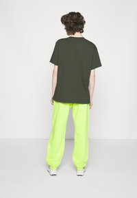 Nike Sportswear W NSW ESSNTL PANT FLC TREND - Calças de fato de treino - atomic green/white