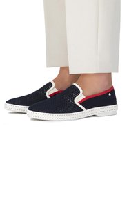 Marine mesh instappers met witte rubberen zolen. Rode accenten langs de zijkant, met een geweven textuur en contrasterende stiksels.