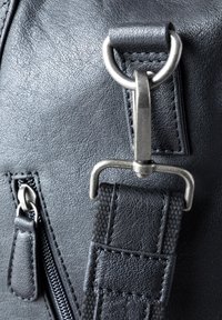 Black leather bag featuring a silver metal hardware clasp, textured surface, zipper detailing, and a woven strap.