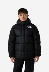 Geacă matlasată neagră cu glugă, cu design matlasat, buzunare frontale și un logo pe piept. Fabricată dintr-un material lucios, izolat.