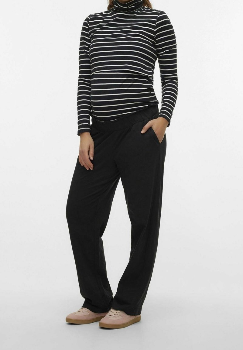 Pantalons noirs à coupe décontractée avec poches latérales, associés à un turtleneck à manches longues noir et blanc à rayures. Offrent une texture douce et extensible.