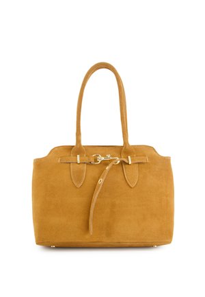 Sac fourre-tout en daim beige avec double poignées et fermeture à boucle dorée, équipé d'une sangle décorative passant à travers le devant.