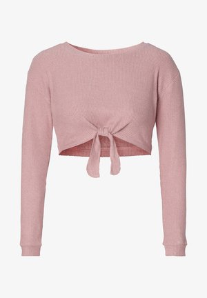 Top court côtelé rose avec manches longues et devant noué. Le tissu a une texture douce, mettant en valeur la coupe ajustée.