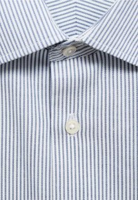 Lähikuva valkoisesta kauluspaidasta, jossa on ohuita sinisiä pystysuoria raitoja ja kaksi näkyvää valkoista nappia kauluksen lähellä.