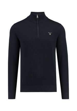 Navy blue, long-sleeve sweater with a high collar, half-zip closure, textured fabric, and a small embroidered logo on the chest.