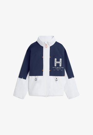 Veste zippée bleu marine et blanche avec col haut, poches poitrine, tirettes de zip noires et logo Tommy Hilfiger Marina Club sur le devant.