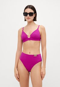 Magenta bikiny set s texturovaným designem; obsahuje trojúhelníkový top s výřezem vpředu a vysoko pasové kalhotky se zlatými akcenty.
