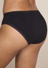 Μαύρο βαμβακερό βρακάκι με διακοσμητική δαντέλα με κυματιστό σχέδιο κατά μήκος της μέσης και των ανοικτών ποδιών, με μαλακή υφή και σχεδιασμό που προσφέρει πλήρη κάλυψη.