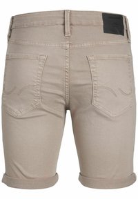 Shorts de mezclilla beige con dobladillos enrollados, dos bolsillos traseros con costuras sutiles y una etiqueta de marca negra en la cintura.