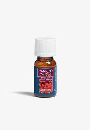 Kleine amberen glazen fles met witte dop, gelabeld Yankee Candle Black Cherry diffuserblend, 10 ml, met kersen afgebeeld op het etiket.