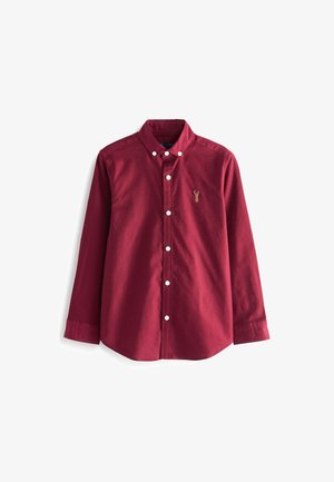 Bordowa koszula na długi rękaw z białymi guzikami oraz małym złotym haftowanym emblematem jelenia na lewej piersi.