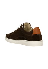 Hnědé semišové tenisky s bílými tkaničkami, bílou gumovou podešví a béžovým koženým akcentem na patě. Zakřivené švy na bocích.