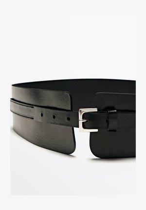 Ceinture en cuir noir avec une texture lisse, un design large et une boucle en métal argenté avec des trous d'ajustement le long de la sangle.