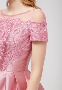 Pink satin dress featuring off-the-shoulder lace detailing, embroidered floral patterns, and a flared skirt design. Smooth texture.