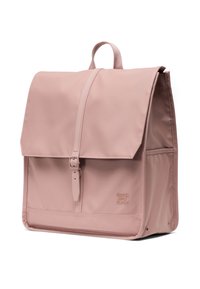 Mochila de nailon rosa con cierre de solapa, correa ajustable y hebilla frontal. Presenta un logo en relieve y un diseño estructurado.