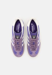 Lilla ruskinds sneakers med hvide læderdetaljer, klassisk design med tre striber, rund tå og tekstureret indersål med brandlogo.