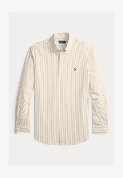 Csíkos hosszú ujjú ing bézs és krém színekben, gombos gallérral, egyetlen zsebbel és egy kis sötétkék logóval a mellkason.