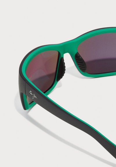 Black and green sunglasses with a curved frame, tinted lenses, textured rubber accents, and logo detail on the side.