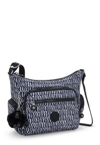 Crossbody-väska i zebra-mönster tillverkad av hållbart tyg. Har svarta detaljer, två fickor med dragkedja och en svart pom-pom charm.