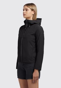 Black, zip-up jacket with a hood, made from a smooth, lightweight material. Features a horizontal chest pocket and logo detail on the sleeve.