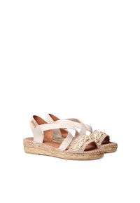 Beige espadrille-sandaalit, joissa on ristimatto-suunnittelu, kudottu yksityiskohta varpaissa ja luonnollinen juuttipohja. Pehmeät kangasremmit ja vaaleanruskea nahkavuori.