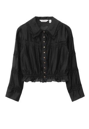 Schwarze, kurz geschnittene Bluse mit Kragen, die mit Spitzenakzenten verziert ist, Knopfverschluss und gerafftem Taillenbund. Lange Ärmel mit Spitzenbordüre.