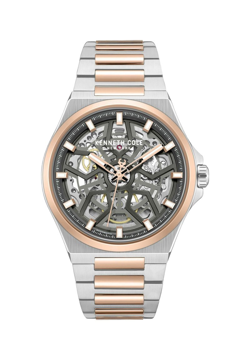 Szkieletowy automatyczny zegarek ze stali nierdzewnej w kolorze srebrnym i różowymi złotymi akcentami. Posiada szary cyferblat, skomplikowany wzór oraz znaczniki godzin.