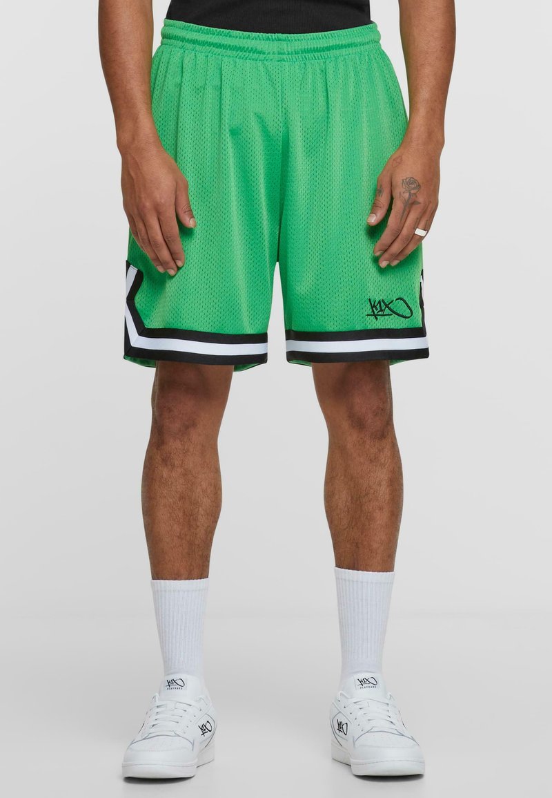 Groene sportshorts van gaas met een zwart-witte gestreepte zoom, met een klein logo op het linkerbeen. Voorzien van een elastische tailleband.