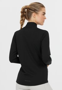 Zwart langslijfs sporttop met hoge kraag, gladde textuur en subtiele "ENDURANCE" logo aan de achterkant, strakke pasvorm voor actieve kleding.