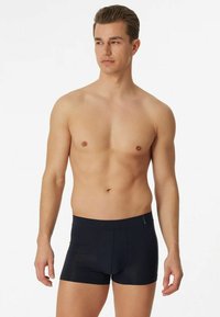Boxer shorts in navy blue, made from a soft cotton blend. Features a fitted design, elastic waistband, and a front pouch.