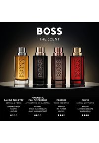 Vier rechthoekige BOSS The Scent parfumflessen in amber, zwart, donkerbruin en rood, elk met unieke geur beschrijvingen eronder.