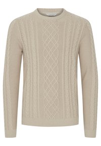 Beige kudumiskampsun, millel on tekstureeritud ketismuster ja soonikkoes varrukate ning alläärega. Klassikaline ümar kaelus ja pikad varrukad.