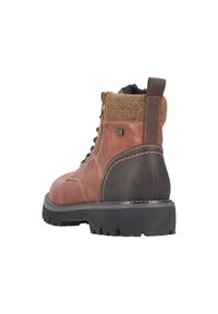 Bruine leren laars met een gestructureerde stoffen kraag, zwarte rubberen zool en zijrits. Voorzien van verstevigde stiksels en een gevoerde enkel.