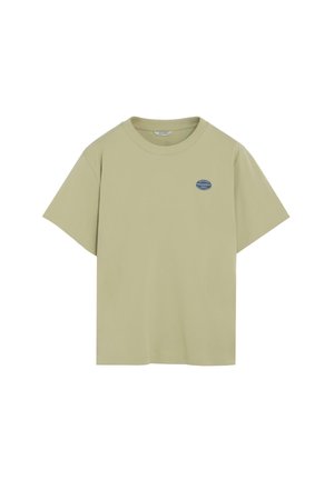 Camiseta beige de manga corta con cuello redondo y pequeño logo circular azul en el lado izquierdo del pecho que dice "Peach Freshfruit 0993".