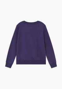 Fialová mikina s dlouhými rukávy, kulatým výstřihem a žebrovanými manžetami. Měkčený materiál se hladkým povrchem, na zadní straně s malou visačkou.