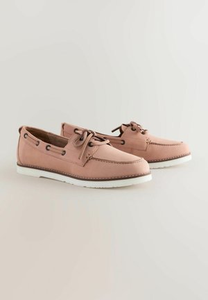 Ljusrosa läderskonor med vita gummisulor, med rund tå, snörning och sidoventilationshål.