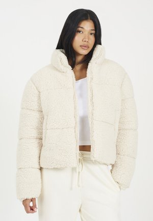 Crème-kleurige fluffy pufferjack met een hoge kraag, ritssluiting en een zachte textuur, met een boxy fit en gestructureerde naden.