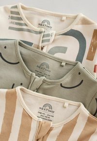 Trois bodies pour bébé à col rond ; les motifs incluent des formes abstraites, des visages souriants et des rayures beiges. Les étiquettes indiquent NEXT baby.