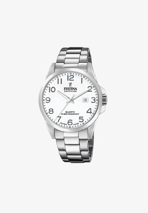 Sudraba nerūsējošā tērauda pulkstenis ar baltu ciparnīcu, lieliem melniem cipariem un datuma funkciju. Aprīkots ar kvarca mehānismu un 10 bāru ūdensizturību.