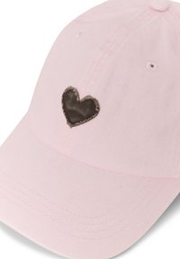 Casquette de baseball rose clair avec un écusson en forme de cœur noir sur le panneau avant, détails cousus et œillets de ventilation.