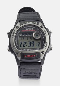 Relógio digital Casio com pulseira de couro preta, caixa de plástico cinza, display LCD, funções de alarme e luz, resistente à água até 50 metros.