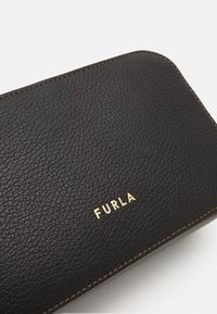 Czarny skórzany portfel o teksturowanej powierzchni, złote logo "Furla" oraz kontrastowe przeszycia na krawędziach.