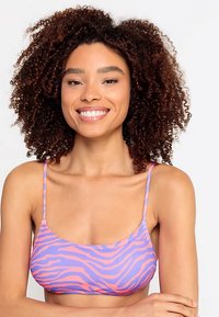 Rožnata in vijolična zebra vzorčasta modrčka z tankimi naramnicami, narejena iz gladkega, raztegljivega materiala, s prilegajočim dizajnom za udobje.
