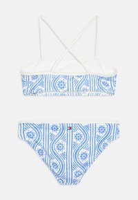 Blå och vit mönstrad bikini med korskonstruktion på ryggen. Har blommotiv och randiga detaljer på toppen och botten.