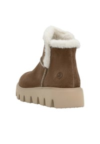 Stivale ankle in suede marrone con fodera in pelliccia sintetica bianca, suola in gomma beige spessa e dettagli di cucitura a contrasto sui lati.