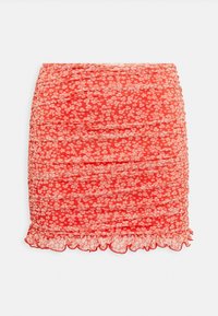 Mini saia com padrão floral vermelho, com textura franzida e barra com babados. Feita de um tecido leve, apresenta pequenas flores brancas por toda a parte.