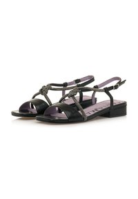 Sandalias de cuero negro con punta abierta, que cuentan con un detalle de malla anudada, una correa ajustable en el tobillo y un tacón bajo. Plantilla morada.