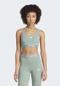 Conjunto de sujetador atlético y leggings en verde claro, con un diseño ajustado, textura suave, acentos de logo blanco y cinturillas anchas con marca.