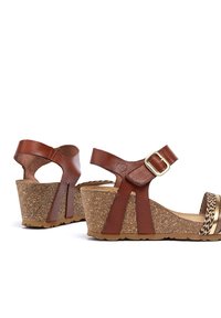 Sandalias de cuña de piel marrón con suela de corcho, tira al tobillo y hebilla dorada. Presentan detalles trenzados en la tira para un toque adicional.